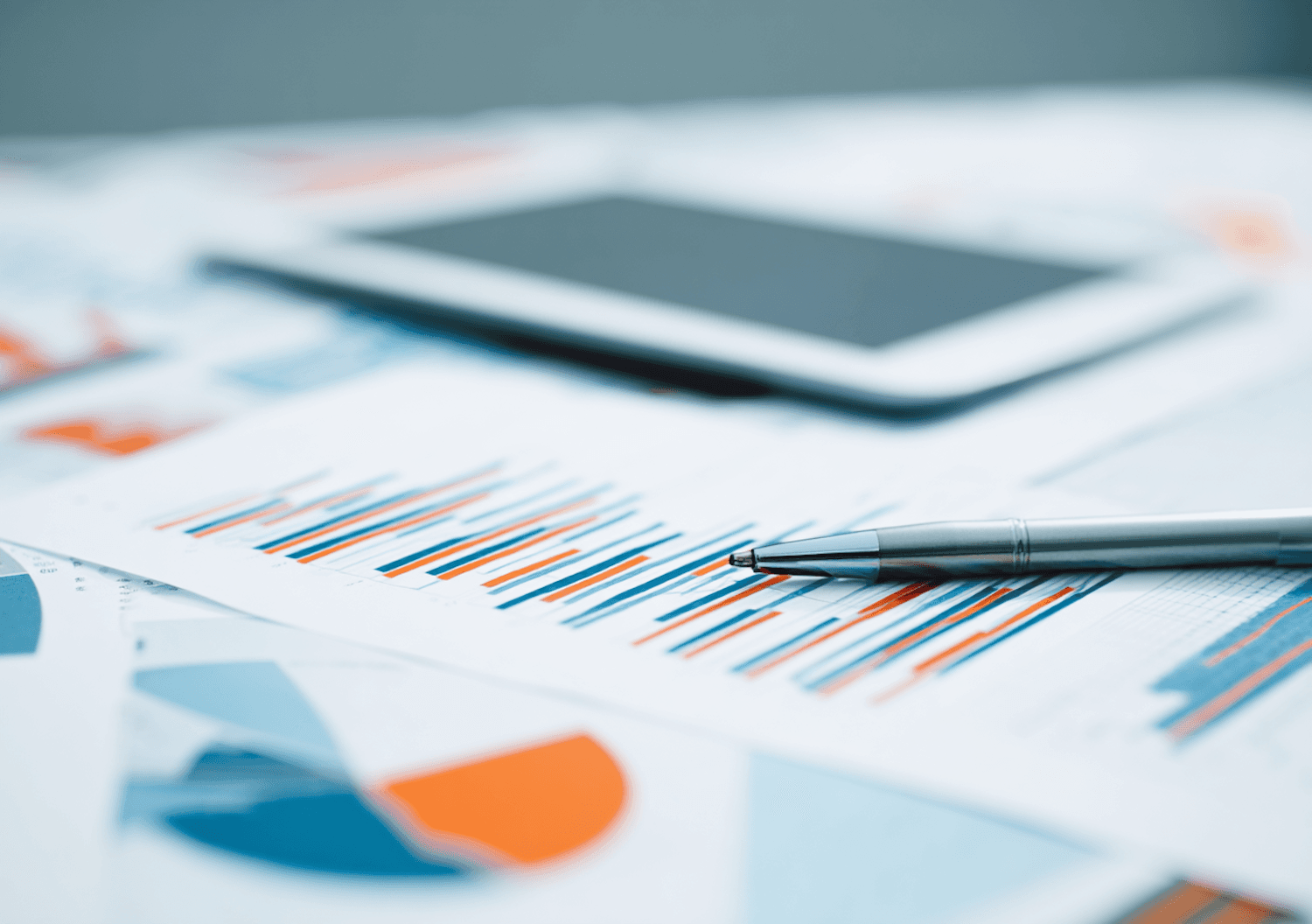 Financial statements, a pen and a tablet on a desk